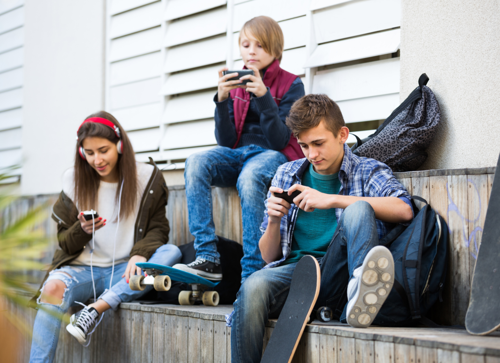 Three teenagers with smartphones in autumn day outside - MR & PR