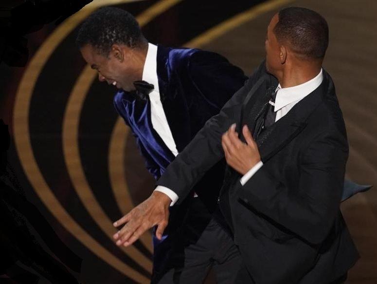 Will Smith, right, hits presenter Chris Rock on stage while presenting the award for best documentary feature at the Oscars on Sunday, March 27, 2022, at the Dolby Theatre in Los Angeles. (AP Photo/Chris Pizzello) Will Smith, right, hits presenter Chris Rock on stage while presenting the award for best documentary feature at the Oscars on Sunday, March 27, 2022, at the Dolby Theatre in Los Angeles. (AP Photo/Chris Pizzello)
